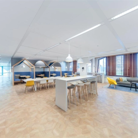 Ruime en moderne kantoorruimte in Voorburg, Loire 104 - 206, met houten vloer en flexibele werkplekken. Ideaal voor wie kantoorruimte wil huren. De ruimte biedt diverse zithoeken en een lange tafel.