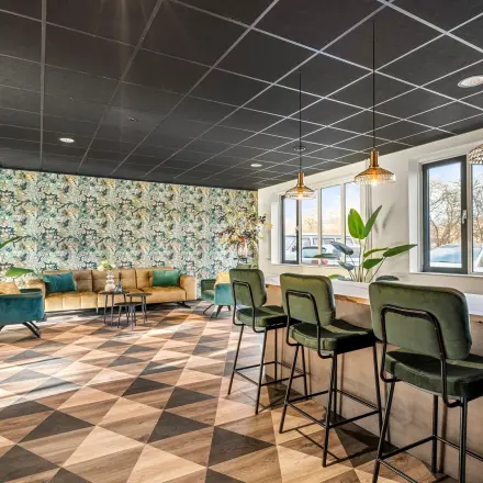 Stijlvolle kantoorruimte met kleurrijke muren en moderne meubels op Agro Business Park 22 in Wageningen. Ideaal voor wie een kantoorpand wil huren. Planten zorgen voor een aangename sfeer.