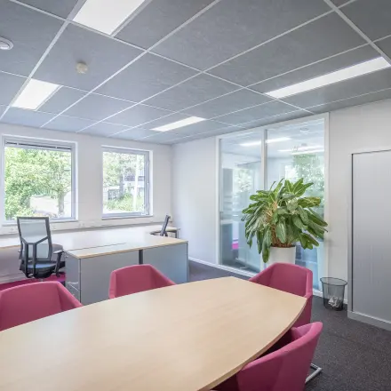 Verlichte kantoorruimte aan Molenweer 2 in Wateringen met grote tafel en stoelen, naast werkruimte aan het raam. Geschikt voor kantoorruimte huren in een functioneel kantoorpand.