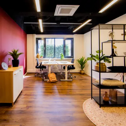 Moderne kantoorruimte huren op Pelmolenlaan 16 in Woerden, met warme houten vloer en decoratieve planten, perfect voor een inspirerende werkomgeving.