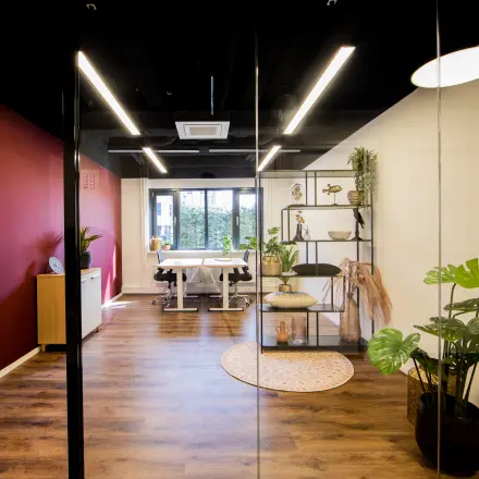 Moderne kantoorruimte huren op Pelmolenlaan 16 in Woerden met een stijlvol interieur, voorzien van houten vloeren en een vergadertafel bij een groot raam.