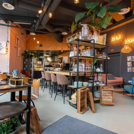 Modern ingerichte kantoorruimte met zitplekken, planten en een caféhoek in kantoorpand Boerhaavelaan 40, Zoetermeer. Ideale plek voor kantoorruimte huren met een creatieve sfeer.