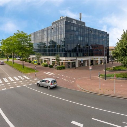 Modern kantoorpand op Stationsplein 4, Zwijndrecht, met grote glaspartijen en een stedelijke omgeving. Ideaal voor kantoorruimte huren dicht bij voorzieningen en openbaar vervoer.