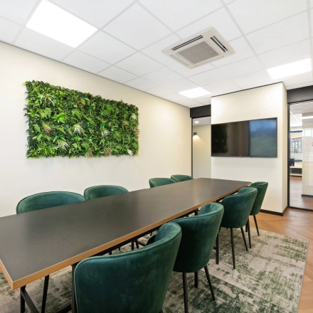 Moderne vergaderruimte in een kantoorpand op Stationsplein 4, Zwijndrecht, met groene accenten en comfortabele stoelen, ideaal voor kantoorruimte huren.