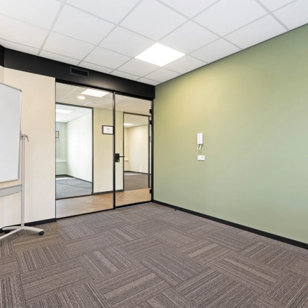 Leeg kantoorpand aan Stationsplein 4, Zwijndrecht, met modern interieur. Ideaal voor wie kantoorruimte wil huren. De ruimte heeft frisse groene accenten en voldoende licht.