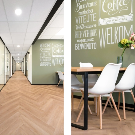 Kantoorruimte huren op Stationsplein 4, Zwijndrecht. Modern interieur met houten vloer en groene muren voorzien van tekst. Witte stoelen rondom een tafel, geschikt voor informele vergaderingen.