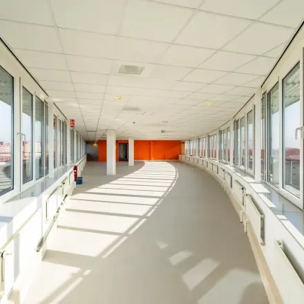 Lichte, ruime gang in kantoorpand op Dokter van Deenweg 1, met grote ramen en uitzicht over Zwolle, perfect voor kantoorruimte huren.