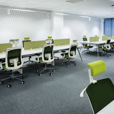 Nowoczesne powierzchnie biurowe do wynajęcia na Kurniki 9, Kraków Stare Miasto, oferujące minimalistyczny design z zielonymi krzesłami i białymi biurkami.