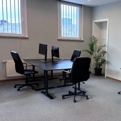 Kantoorruimte te huur op Avenue Palmerston 3 in Brussel Europese Wijk met een vergadertafel, vier stoelen en twee beeldschermen, ideaal om kantoorruimte te huren.