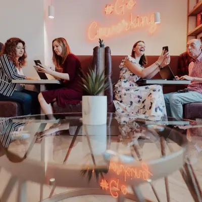 Een levendige coworking ruimte in Brussel, gelegen aan Robert Schumanplein 2-4, met mensen die samenwerken en gebruik maken van de kantoorruimte te huur.