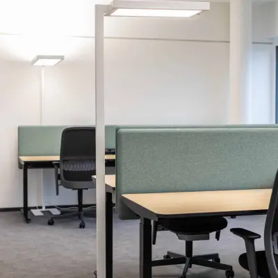 Moderner Büroraum in Siemensstraße 89, 1210 Wien Floridsdorf, mit grünen Akustikpaneelen und ergonomischen schwarzen Bürostühlen. Perfekt für alle, die eine Bürofläche mieten möchten.