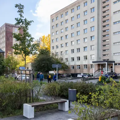 Außenansicht eines Bürogebäudes in Berlin Friedrichshain mit umliegendem Grün und geparkten Autos; ideal für Büro mieten.