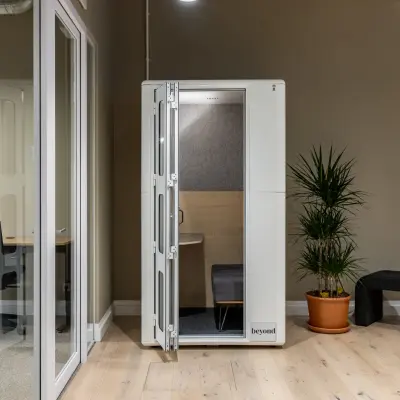 Modernes Büro mit schallisolierter Kabine, ideal für konzentriertes Arbeiten. Die Bürofläche in der Chausseestraße 29, Berlin Kreuzberg, bietet diesen cleveren büroraum mieten Service.