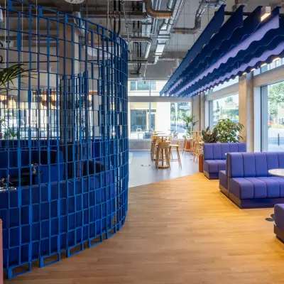 Modernes Büro in Berlin Mitte mit stilvollen blauen Trennwänden und Sitzbereichen, ideal zum Büro mieten und kreativ arbeiten.