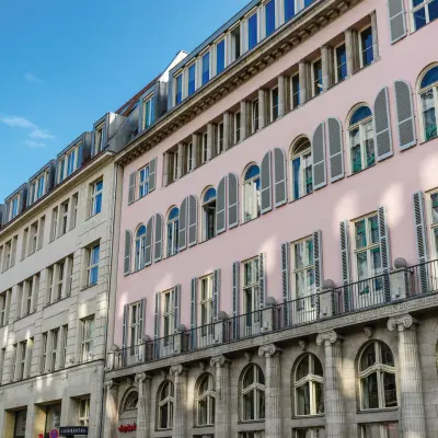 Die Fassade eines Bürogebäudes in Berlin Mitte, Unter den Linden 26-30, ideal für alle, die Bürofläche mieten möchten. Klassische Architektur mit hohen Fenstern.