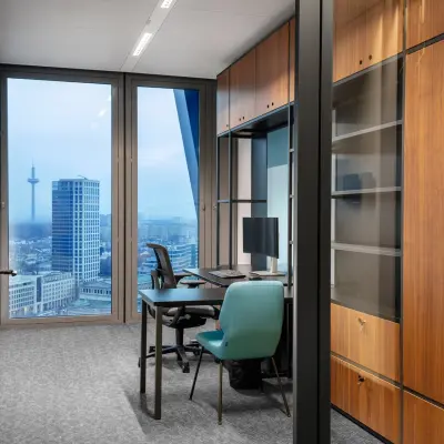 Modernes Büro mit Blick auf die Skyline in der Junghofstraße 9, Frankfurt Innenstadt. Ideal für Bürofläche mieten mit Schreibtischen, Stühlen und einem eleganten Holzschrank.