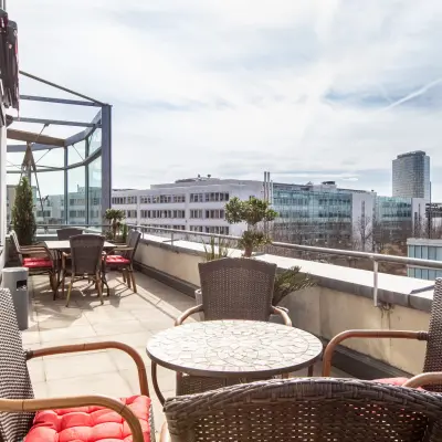 Terrasse mit Sitzgelegenheiten und Ausblick auf moderne Bürogebäude in München Laim auf der Landsberger Straße 155.