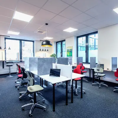 Helles Büro in München Laim mit modernen Schreibtischen und ergonomischen Stühlen, ideal für die Bürofläche mieten. Große Fenster bieten viel Tageslicht.