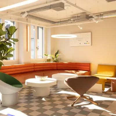 Modernes, möbliertes Büro zur Miete an der Beethovenstrasse 48 in Zürich Enge mit stilvollen Sesseln und einer Ecke mit roter Couch.