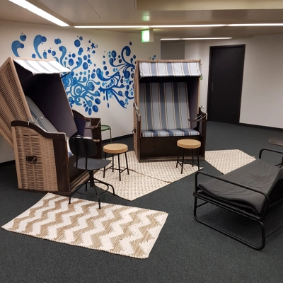Kreativer Büroraum mit Strandkorbmöbeln und moderner Wandgestaltung in Zürich Enge, ideal für ein außergewöhnliches Büro mieten.