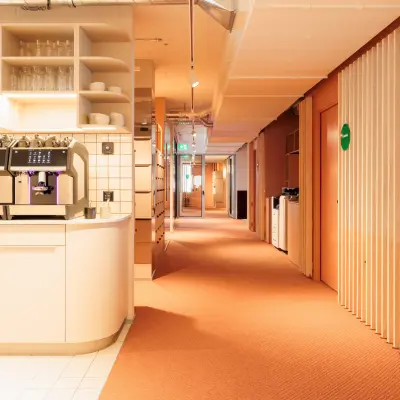 Gemütlicher Büroraum in der Stockerstrasse 33, Zürich Enge; möbliert mit Pantrybereich, perfekt für büro mieten. Heller Gang mit Regalen und Kaffeemaschine.