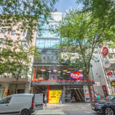 Street view of Mariahilfer straße 36 in 1070 Vienna, featuring a modern building with glass facade, ideal for office space rental.