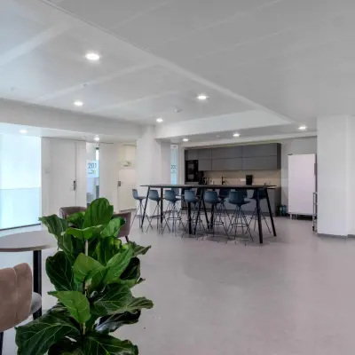 Modern furnished office space at Siemensstraße 89, Vienna, perfect for rent. Features a sleek area with seating and a long counter ideal for collaboration.