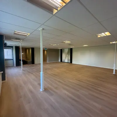 Interior view of unfurnished office space at Hollandse Kade 38, Abcoude, featuring a wooden floor and white walls, ideal for office space rental.