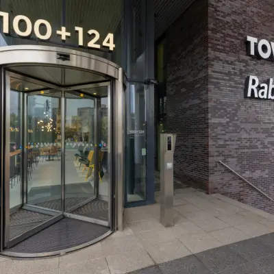 Entrance to office space rental at Landdrostdreef 124, Almere Stad, featuring a modern revolving door and sleek signage.