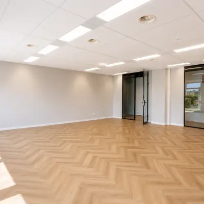 Spacious office with wooden flooring and ceiling lights at Veluwezoom 15, Almere Stad, available for office space rental.