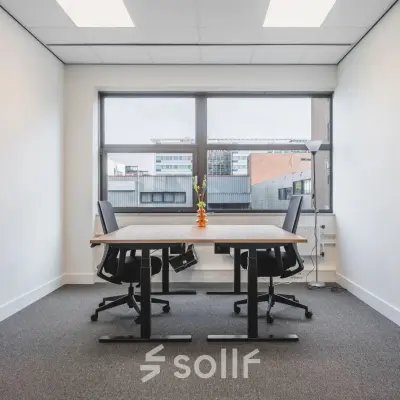 Interior office space at Veluwezoom 15 in Almere Stad, featuring a furnished workspace with a large window. Ideal for office space rental opportunities.