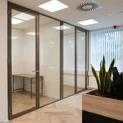 Bright, modern office space at Maanlander 43, Amersfoort Calveen, featuring glass-walled sections and natural lighting, available for rent.