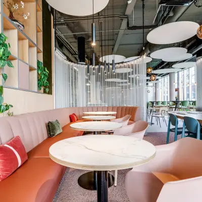 Furnished office space for rent at Maanlander 47, Amersfoort Calveen, featuring modern seating with stylish lighting and greenery.