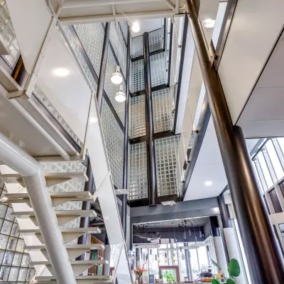 Modern office interior at Maanlander 47, Amersfoort Calveen with spacious stairway and sleek glass features, highlighting attractive office space rental opportunities.