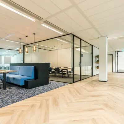 Modern office space at Spoetnik 10-64 in Amersfoort Calveen, featuring stylish furnishings and glass-partitioned meeting areas, available for office space rental.