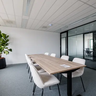 Bright office space at Stadsring 201 featuring a long table with chairs, ideal for meetings. Large windows illuminate the room, making it a perfect office space rental in Amersfoort Centrum.