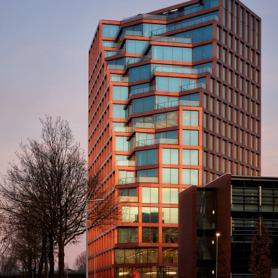 Exterior view of a modern office building at H.J.E. Wenckebachweg 230-258, located in Amsterdam Amstel Business Park. Tall structure features reflective glass windows and contemporary design, ideal for office space rental.