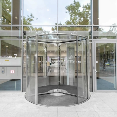 Exterior view of the office building at Mr. Treublaan 7, Amsterdam Amstel, featuring a modern revolving door entrance for office space rental.
