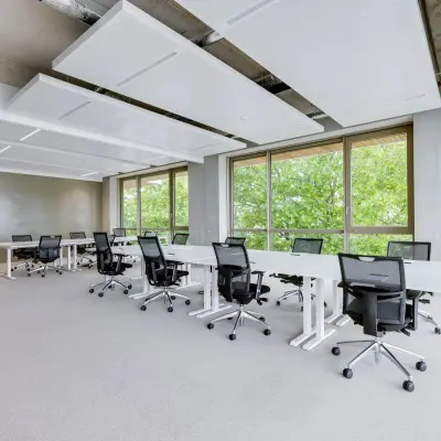 Modern office space rental at Willem Fenengastraat 16, Amsterdam Amstel, featuring large windows and ergonomic chairs around sleek desks.