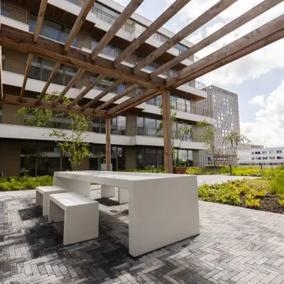 Outdoor communal area at Willem Fenengastraat 16, Amsterdam Amstel, suitable for rent office space with modern seating under a wooden pergola. Office space rental available nearby.