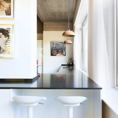 Stylish office interior at Teilingen 1 in Amsterdam Buitenveldert, featuring a sleek counter with two modern bar stools under pendant lights, perfect for relaxed breaks. Ideal for office space rental.