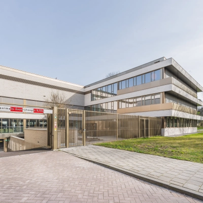 Exterior view of office space for rent at Walborg 2A, Amsterdam Buitenveldert, featuring a modern building with greenery.