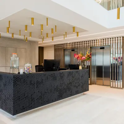 Modern reception area with sleek black desk and decorative lighting in an office space for rent at Walborg 2A, Amsterdam Buitenveldert.