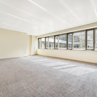 Bright, unfurnished office space available for rent at Walborg 2A, Amsterdam Buitenveldert, featuring large windows letting in natural light.