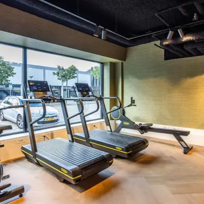 Office space rental gym area with treadmills and exercise bikes by a large window at Zwaansvliet 1, Amsterdam Buitenveldert.