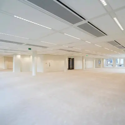 Spacious office space for rent at Herengracht 459-469 in Amsterdam Canal Belt, with an open layout and ample natural light streaming through large windows.