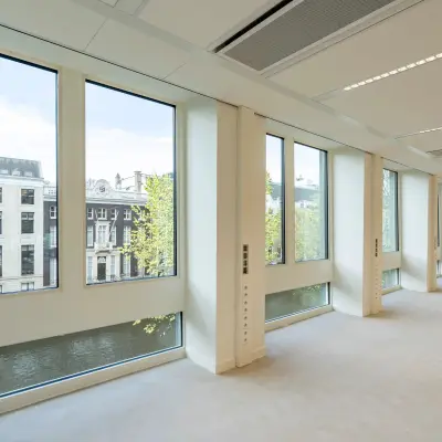 Interior view of an office space rental at Herengracht 459-469, featuring large windows and abundant natural light with canal views in Amsterdam Canal Belt.