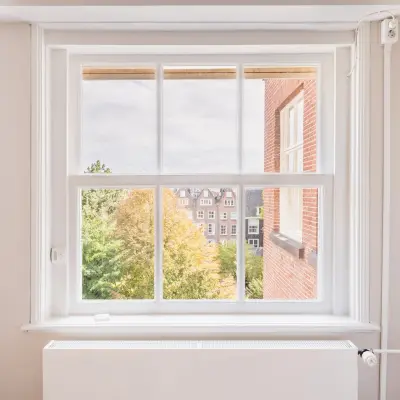 Bright office space rental at Herengracht 582-584 in Amsterdam Canal Belt, featuring a large window with a view of the historic cityscape.