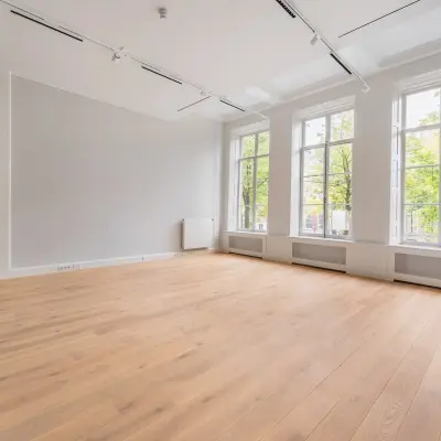 Spacious office to rent at Herengracht 582-584 in the Amsterdam Canal Belt, featuring large windows and wooden flooring, perfect for office space rental.