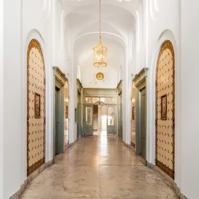 Elegant entrance hallway with classic arches, ornate chandeliers, and vintage decor details at Keizersgracht 261 in Amsterdam Canal Belt, ideal for office space rental.